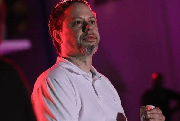 Original reference photograph of Tristan on a stage with red lighting